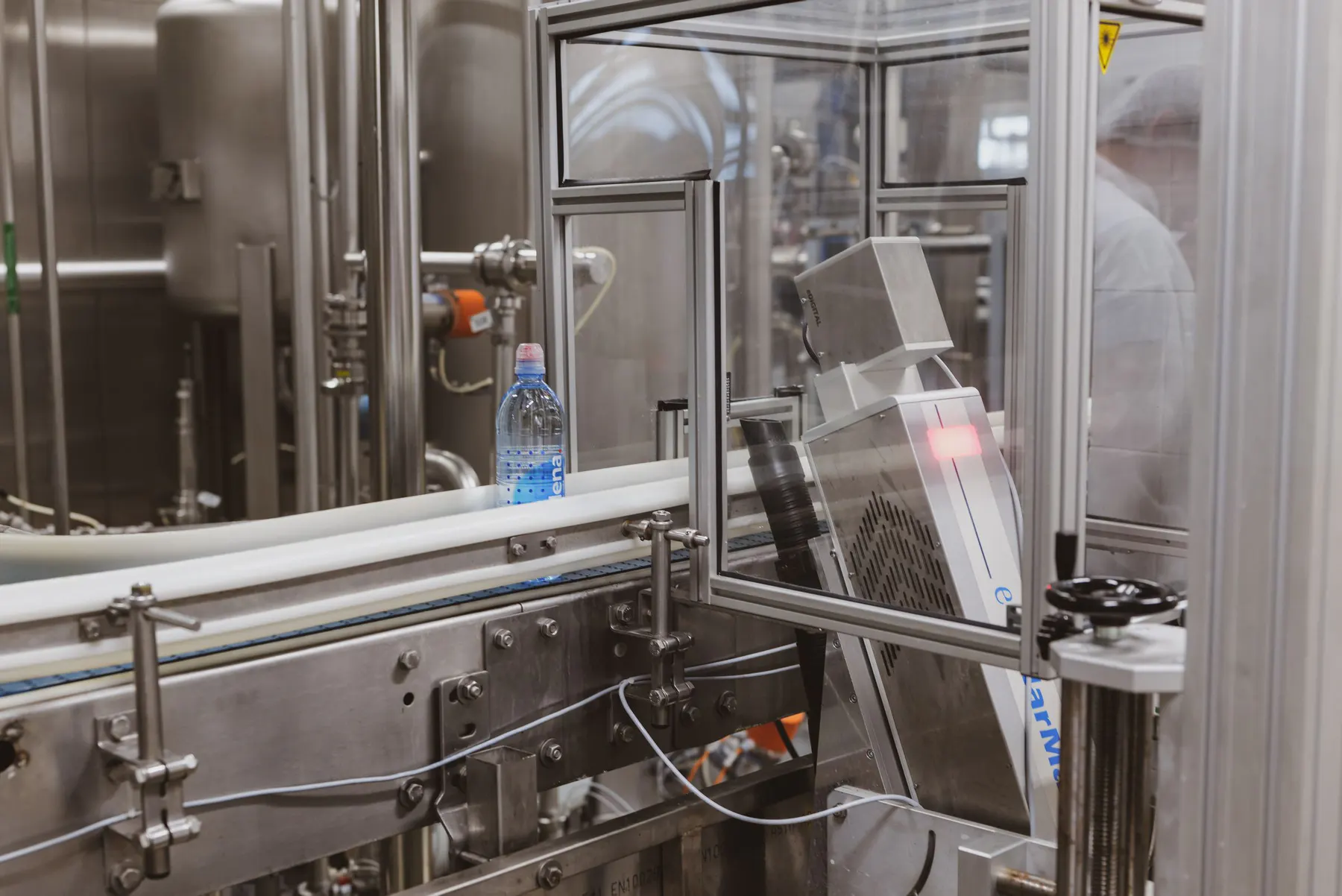 Automated bottle moving through a stainless-steel filling line