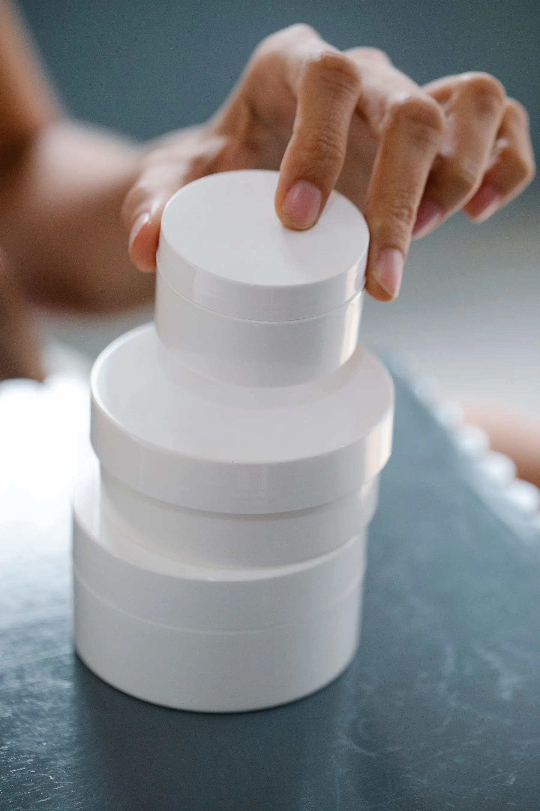 Unbranded white cosmetic jars prepared for personal-care products