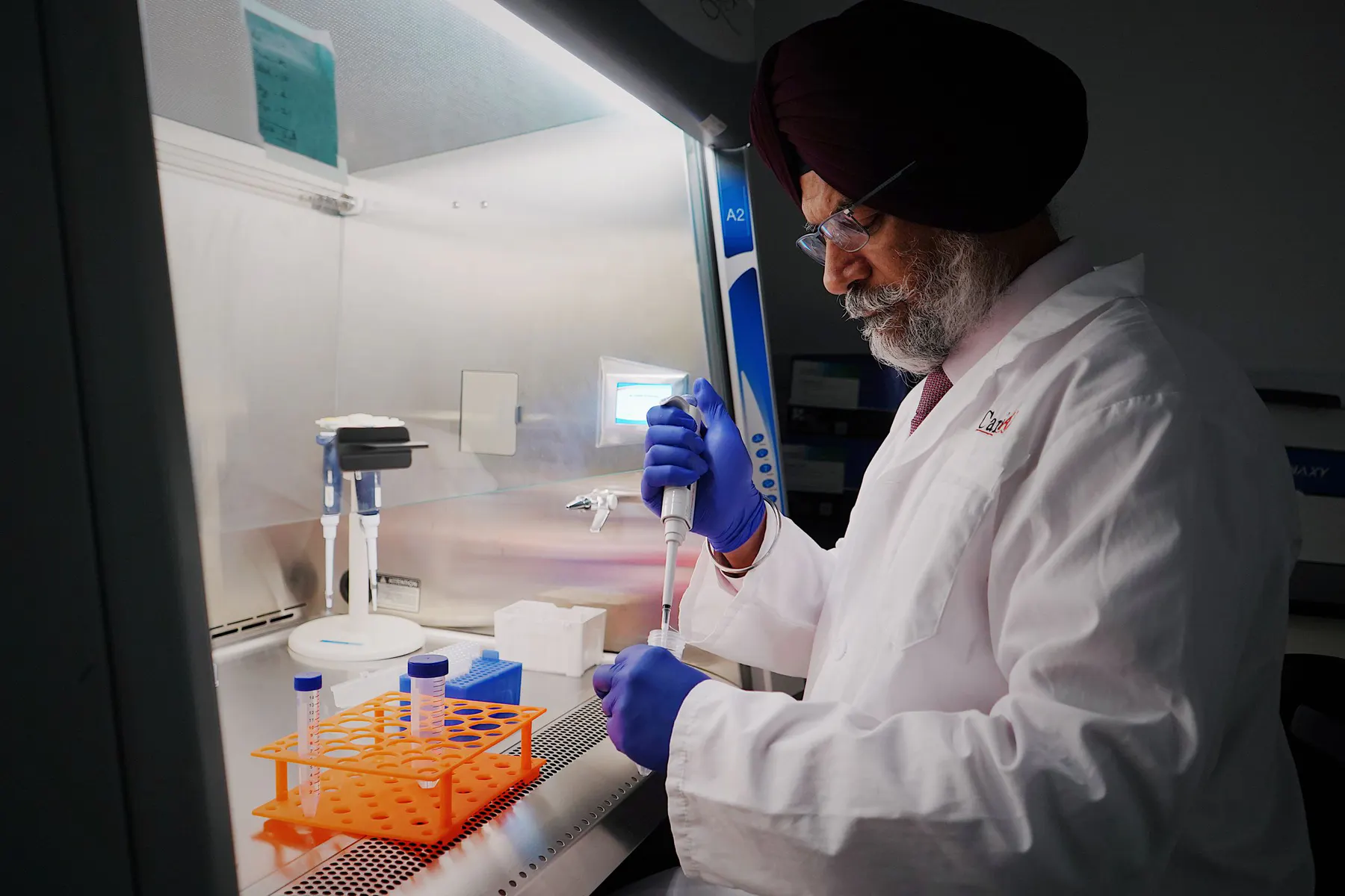 Life-science researcher performing a controlled pipetting procedure